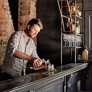 Barman du Pub G6 servant un verre de whisky single-malt