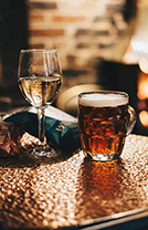Un verre de bière et une coupe de vin sur une table au Pub G6